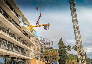 El disco gigante se eleva hasta la abertura del edificio mediante un sistema de ventosas de vacío y una viga de contrapeso