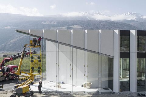 Montaje de un megacristal en la fachada en forma de diente de sierra mediante un sistema de succión al vacío.