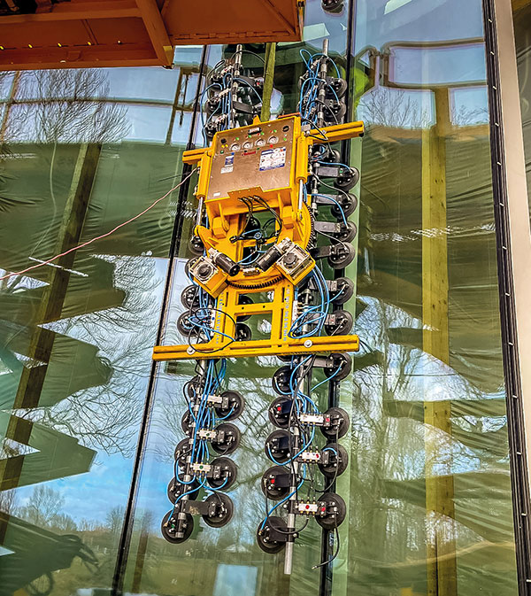 Instalación de la fachada de la Biblioteca Galinciems en Ventspils (Letonia) con el sistema de aspiración Heavydrive VSG 1500 KR MH para cristales curvos.