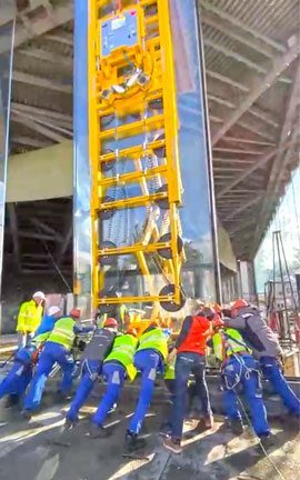 Varias personas presionan con la mano el borde inferior contra el peso del cristal en el orificio de montaje.