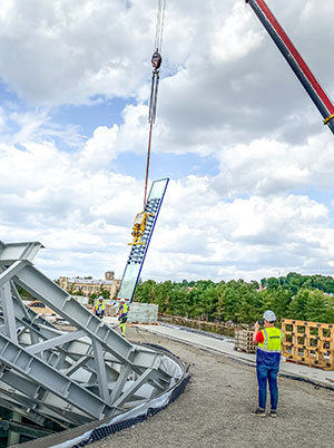 El sistema de aspiración Heavydrive eleva un panel curvado bajo la estructura de acero del Centro de Ciencia e Innovación de Kaunas.